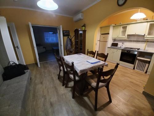 a kitchen and dining room with a table and chairs at Sándor Apartman in Gyula