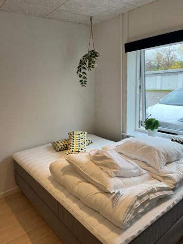 a large bed in a room with a window at Billund mini hostel room 2 in Billund