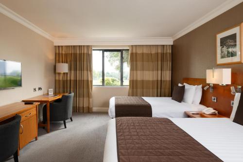a hotel room with two beds and a desk at Roe Valley Resort in Limavady
