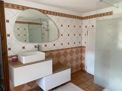 une salle de bain avec un lavabo et un miroir dans l'établissement Maison pleine de charme située sur une zone touristique, à Saint-Christophe-Vallon