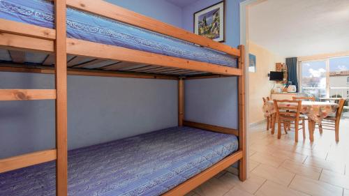 - une chambre avec 2 lits superposés et une salle à manger dans l'établissement Le Colisee A N23 - ST4, au Cap d'Agde