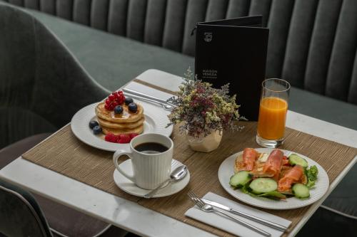 a table with two plates of breakfast food and a cup of coffee at Maison Venezia | UNA Esperienze in Venice
