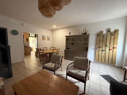 - un salon avec une table, des chaises et des skis dans l'établissement les vents qui soufflent, au Crotoy