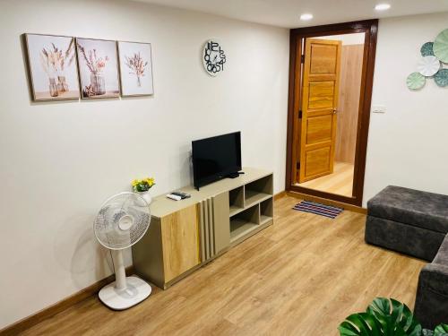 a living room with a television and a couch at Baannira บ้านนิรา in Ban Sam Kong