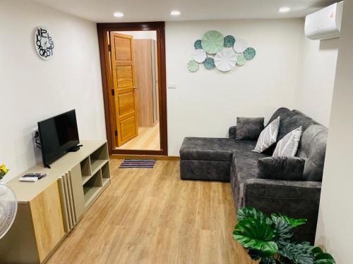 a living room with a couch and a television at Baannira บ้านนิรา in Ban Sam Kong