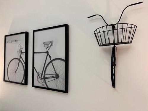 two framed pictures and a bike on a wall at Raroom Deluxe V Room in Torre del Greco