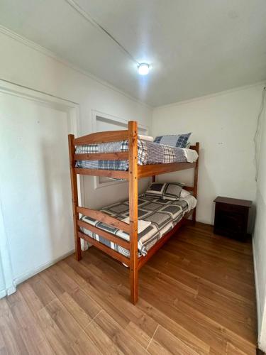 a bunk bed in a room with a wooden floor at Sunset Iquique in Iquique
