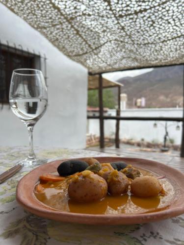 a plate of food on a table with a glass of wine at Casa en el corazón de Huacalera, Jujuy in Tilcara