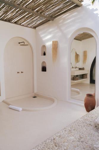 a white room with a vase on the floor at Anacardier Privé Hotel in Atins
