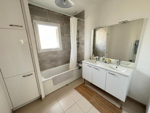 une salle de bain avec un lavabo, une baignoire et un miroir dans l'établissement Escapade Féline, à Mimizan-Plage