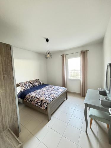 une chambre avec un lit, un bureau et une fenêtre dans l'établissement Escapade Féline, à Mimizan-Plage