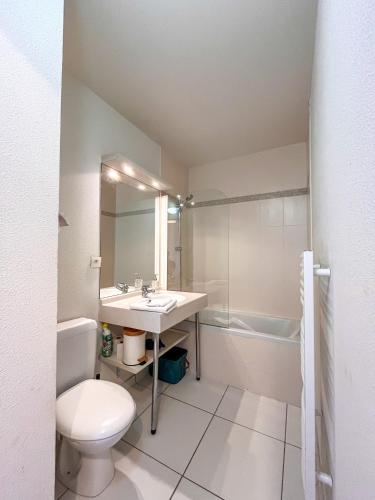 une salle de bain avec un lavabo, des toilettes et une baignoire dans l'établissement Appartement Cosy, terrasse vu mer, piscine, Sauna - WarmHouse, à Plougonvelin