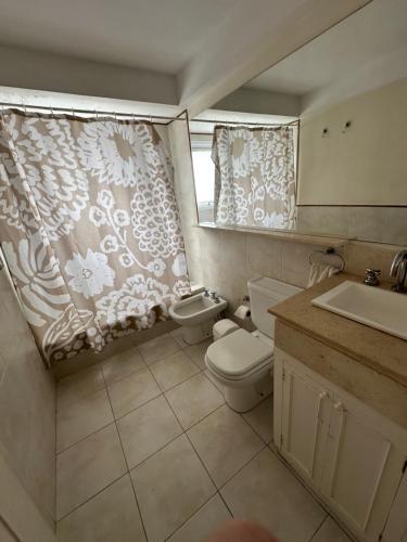 a bathroom with a toilet and a sink and a window at Alberti Apartament in San Isidro