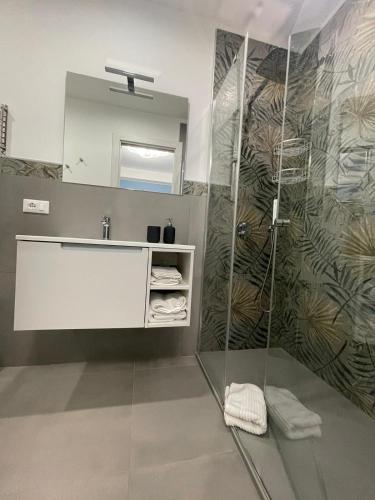 a bathroom with a shower with a sink and a mirror at Casa Vacanza Da Angela & Corrado in Pozzallo