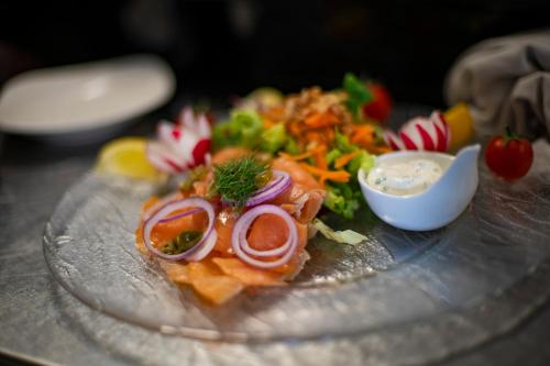 a plate of food with vegetables and sauce on it at Logis Hôtel & Restaurant Au Lion d'Or in Burnhaupt-le-Haut