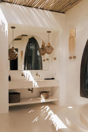 a bathroom with a sink and a mirror at Anacardier Privé Hotel in Atins