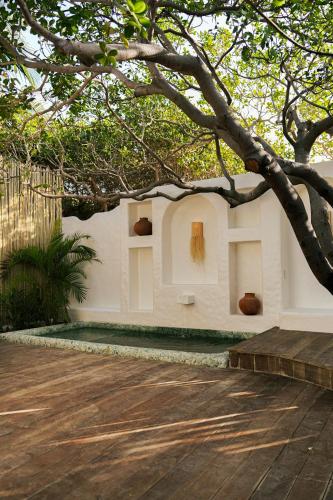 a white building with a tree in front of it at Anacardier Privé Hotel in Atins