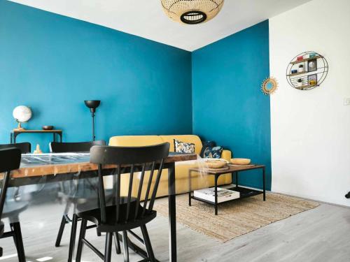 une salle à manger avec des murs bleus et une table et des chaises dans l'établissement L'échappée belle, parking, climatisation, 5min à pied du centre historique, à Avignon