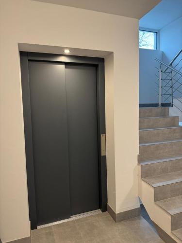 a large black door in a building with stairs at Wunderschöne Ferienwohnung in Leipzig Taucha 1 OG Mitte in Taucha