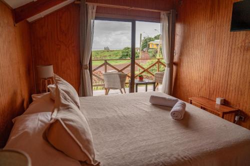 a bedroom with a bed with a view of a balcony at Cabañas Anavai Rapa Nui in Hanga Roa