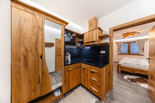 a kitchen with wooden cabinets and a sink in a room at ANTONIO Apartments in Spišské Tomášovce