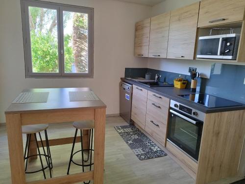 une cuisine avec un comptoir et un îlot avec des tabourets dans l'établissement maison la garenne, à Royan