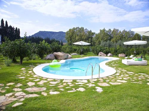 a swimming pool in the middle of a grass field at Luna&Limoni Country in Muravera