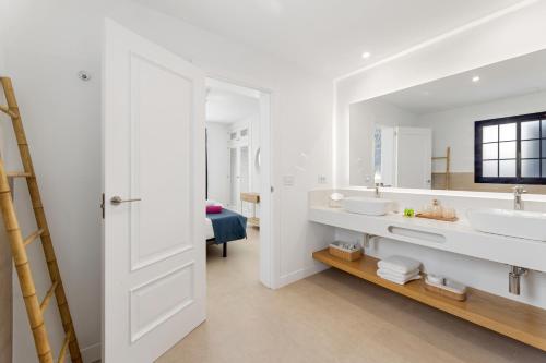 a white bathroom with two sinks and a mirror at Villas Volcan in Playa Blanca