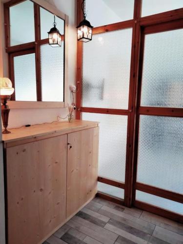 a room with two windows and a wooden cabinet at Casa Amorì in Castel di Sangro