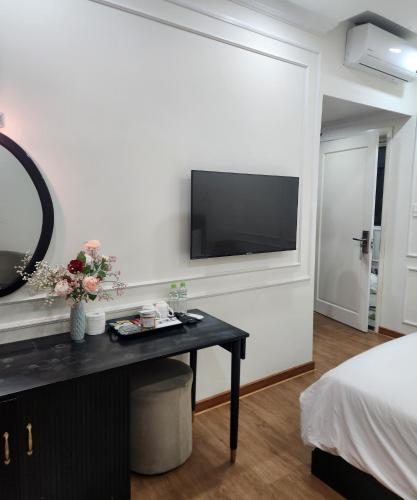 a bedroom with a table with a television on a wall at BREAKING DAWN- TAEYANG Hotel Phú Quốc in Phu Quoc
