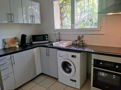 une cuisine avec un lave-linge et un micro-ondes dans l'établissement Two-bedroom Villa Provençal avec la piscine, à Aix-en-Provence