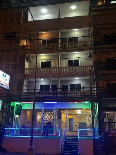an apartment building with a balcony at night at MAGNIFICo INN PATTAYA in Pattaya
