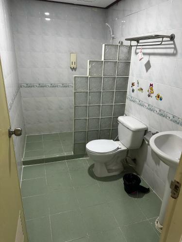 a bathroom with a toilet and a shower and a sink at MAGNIFICo INN PATTAYA in Pattaya