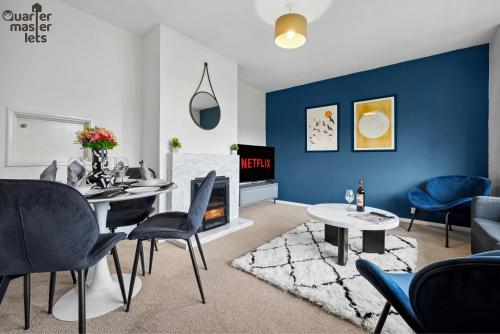 a living room with blue walls and a table and chairs at 2 Bedroom Bungalow with Parking that Sleeps 6 in West Horsley