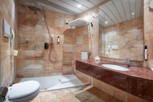 a bathroom with a toilet and a sink and a shower at Mediterraneo Palace Hotel in Ragusa
