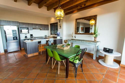 a kitchen with a table and green chairs in a room at Villa Jade in San Miguel de Allende