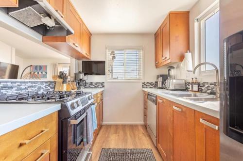 a kitchen with wooden cabinets and a stove top oven at Exclusive Ocean & Pier View Family Escape in Manhattan Beach