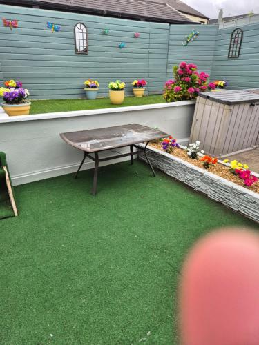 a patio with a table and some flowers and plants at 17 DB property in Wexford