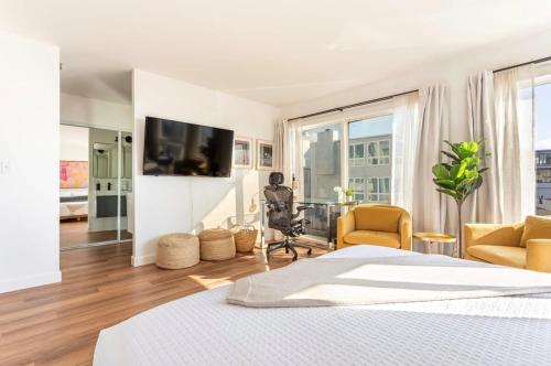 a bedroom with a bed and a desk and a tv at Exclusive Ocean & Pier View Family Escape in Manhattan Beach