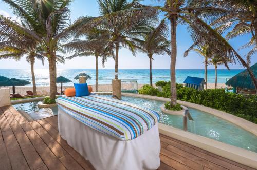a resort patio with a pool and palm trees at The Pyramid Cancun by Oasis - All Inclusive in Cancún