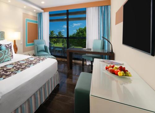 a hotel room with a bed and a bowl of fruit at The Pyramid Cancun by Oasis - All Inclusive in Cancún