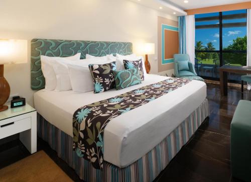 a hotel room with a large bed and a balcony at The Pyramid Cancun by Oasis - All Inclusive in Cancún