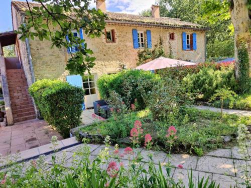 a garden in front of a stone house at Le Mas des Laurels in Chantemerle-lès-Grignan
