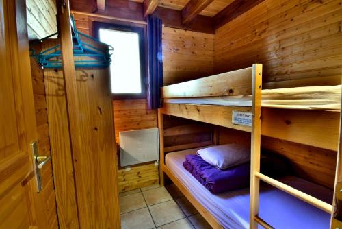 a bedroom with two bunk beds in a wooden cabin at Calme et la plus belle vue des environs #Chalet in Saint-Floret
