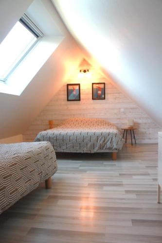 une chambre avec deux lits dans un grenier dans l'établissement Gite de groupe 