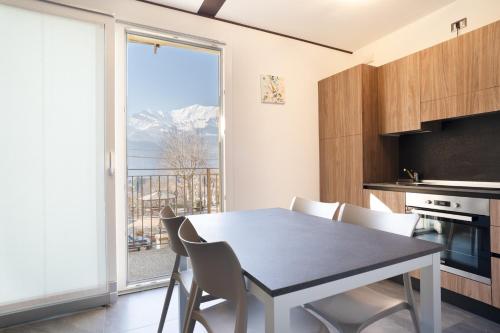 a kitchen with a table and chairs and a large window at Residence La Corte di San Rocco in Cremeno