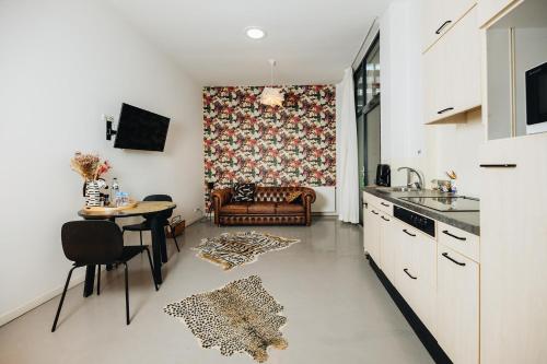a kitchen and living room with a table and a couch at Hotel Zilt Studio's in Vlissingen