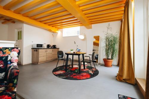 a living room with a table and a kitchen at Hotel Zilt Studio's in Vlissingen
