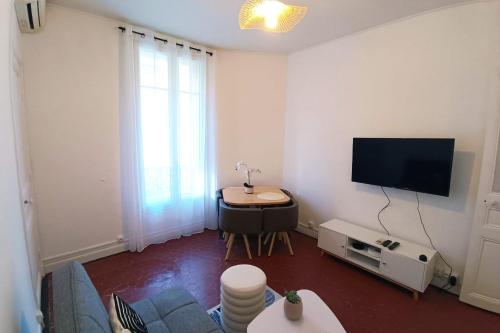 un salon avec une télévision et une table dans l'établissement Charming T3 near the city center - Nice, à Nice