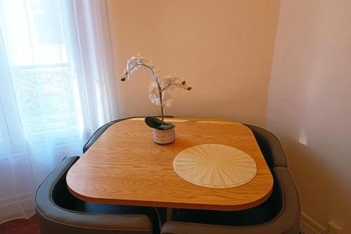 une table en bois avec une plante dans un vase dans l'établissement Charming T3 near the city center - Nice, à Nice